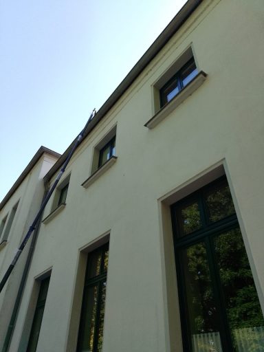 Fassade eines modernen Gebäudes mit mehreren Fenstern und einem blauen Farbton.